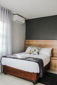 a bedroom with a bed with a wooden headboard at The Rainbowtree B&B in Gaborone