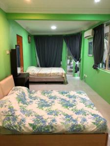 a bedroom with two beds and green walls at Supreme Homestay in George Town