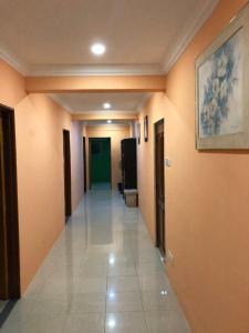 a hallway with orange walls and a painting on the wall at Supreme Homestay in George Town