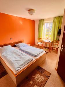 1 dormitorio con 1 cama con pared de color naranja en Hotel zur Post, en Schalksmühle