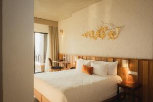 a hotel room with a bed and a table and a window at Natee The Riverfront Hotel Kanchanaburi in Kanchanaburi