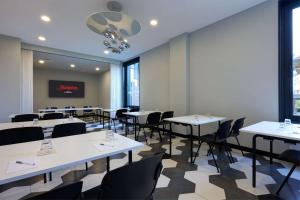 a dining room with white tables and chairs at Hampton by Hilton Rome North Fiano Romano in Fiano Romano
