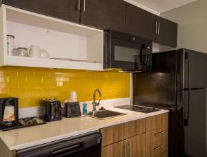 a kitchen with a sink and a refrigerator at MainStay Suites Savannah Midtown in Savannah