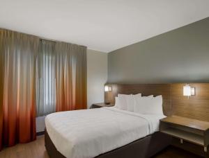 a bedroom with a large white bed and a window at MainStay Suites Savannah Midtown in Savannah