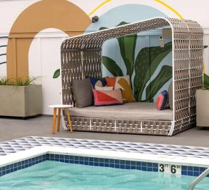 a wicker pergola sitting next to a swimming pool at Inn at the Pier Pismo Beach, Curio Collection by Hilton in Pismo Beach