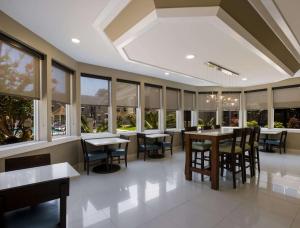 a dining room with tables and chairs and windows at MainStay Suites Savannah Midtown in Savannah