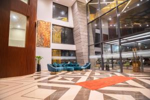 a lobby with blue couches in a building at Ramada by Wyndham Murree Lower Topa Resort in Murree