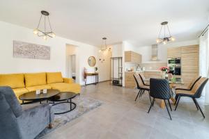 a living room with a couch and a table and chairs at Villa Janie - Modern Pool Apartments Splitska in Splitska