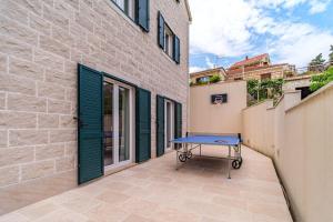 a blue table sitting in the courtyard of a building at Villa Janie - Modern Pool Apartments Splitska in Splitska