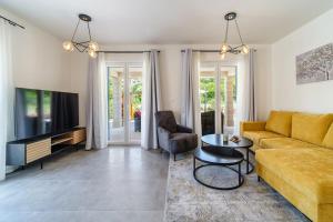 a living room with a couch and a table at Villa Janie - Modern Pool Apartments Splitska in Splitska