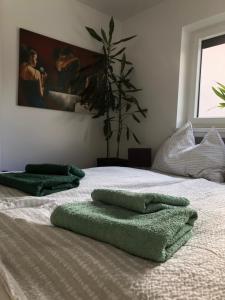 a bed with green towels on top of it at myurlaub(.)at in Finkenstein