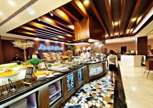 uma fila de buffet num restaurante com pessoas a preparar comida em The Heritage Hotel Manila em Manila