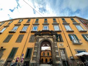 a large yellow building with an arch in front of it at Maison Degas-Dimora di Charme in Naples
