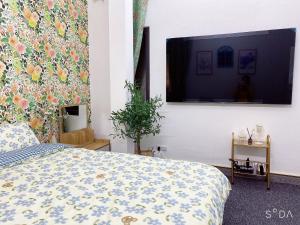 a bedroom with a bed and a flat screen tv at FlowerGod Apartments - BlackPink HomeStay in Hanoi