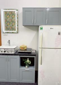 a kitchen with a white refrigerator and a sink at FlowerGod Apartments - BlackPink HomeStay in Hanoi