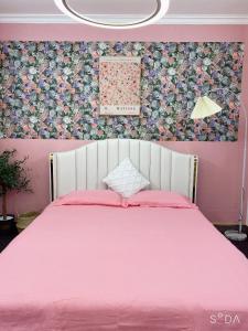 um quarto rosa com uma cama com uma colcha rosa em FlowerGod Apartments - BlackPink HomeStay em Hanói