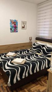 a bedroom with a black and white striped bed at Stan u centru, Loznica in Loznica