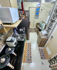 High-Tech Studio at Grass Residences -2 persons only, Quezon City في مانيلا: مطبخ صغير مع موقد ومغسلة