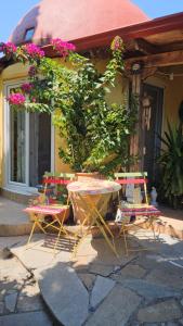 une table et des chaises devant un bâtiment fleuri dans l'établissement Home & Gardens 2-Bed Villa in Sevasti Katerini, à Kateríni