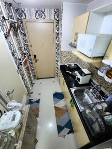 una pequeña cocina con fregadero y encimera en High-Tech Studio at Grass Residences -2 persons only, Quezon City, en Manila