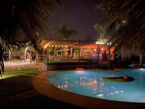 - une piscine en face d'une maison la nuit dans l'établissement Duas Quintas Areal, à Guimarães