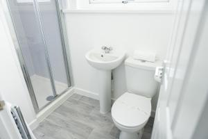 a white bathroom with a toilet and a sink at Fred's Place in Plymouth