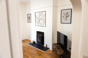 a living room with a fireplace and a tv at Fred's Place in Plymouth