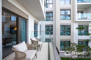 - un balcon dans un bâtiment avec des chaises et des tables dans l'établissement Dream Inn - Address Beach Residence Fujairah - Premium Apartments, à Fujaïrah