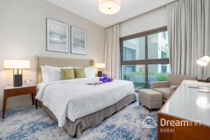 a bedroom with a bed and a chair and a window at Dream Inn - Address Beach Residence Fujairah - Premium Apartments in Fujairah