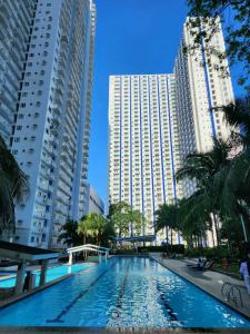 マニラにあるHigh-Tech Studio at Grass Residences -2 persons only, Quezon Cityの高層ビル2棟の中央にスイミングプールがあります。