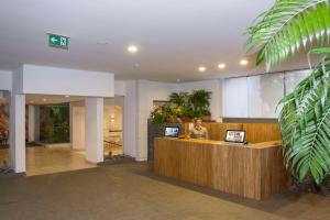 a woman standing at a reception desk in a lobby at Dorisol Mimosa Studio Hotel in Funchal