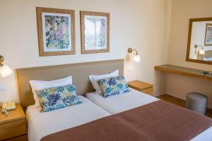a hotel room with a bed and two pillows at Dorisol Mimosa Studio Hotel in Funchal
