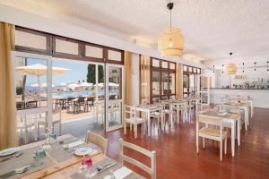 a restaurant with tables and chairs and a pool at Dorisol Mimosa Studio Hotel in Funchal