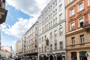 Un edificio bianco con una statua sul lato. di Theatre 9 Apartments by Adrez a Praga