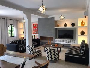 Elle comprend un salon doté de meubles et d'une cheminée. dans l'établissement VILLA PISCINE MARRAKECH, à Marrakech