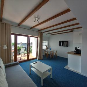 a living room with a couch and a table at Apartamenty Na Fali in Jastarnia