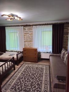 een woonkamer met een bank en een tafel bij Kvartura z dvorukom in Kamjanets-Podilsky