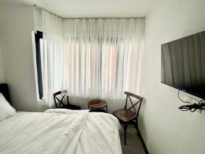a bedroom with a bed and two chairs and a window at Noya Suites in Istanbul