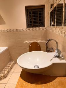 a bathroom with a white sink and a tub at Adorable 2 Bedroom Couple and Family-Friendly Home in Clacton-on -Sea - Coastal Comforts Retreat in Clacton-on-Sea