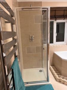 a shower with a glass door in a bathroom at Adorable 2 Bedroom Couple and Family-Friendly Home in Clacton-on -Sea - Coastal Comforts Retreat in Clacton-on-Sea
