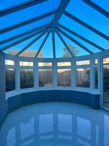 un giardino d'inverno con tetto in vetro e finestre di Adorable 2 Bedroom Couple and Family-Friendly Home in Clacton-on -Sea - Coastal Comforts Retreat a Clacton-on-Sea