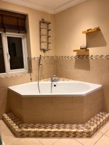 a large bath tub in a bathroom with a window at Adorable 2 Bedroom Couple and Family-Friendly Home in Clacton-on -Sea - Coastal Comforts Retreat in Clacton-on-Sea