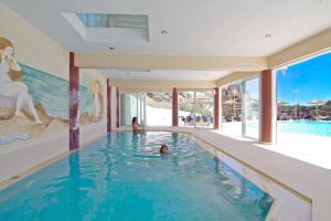 eine Person, die in einem Schwimmbad in einem Haus schwimmt in der Unterkunft Kalypso Cretan Village Resort & Spa in Plakias