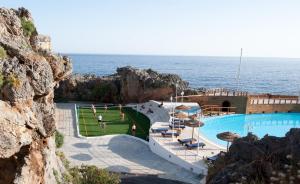 Blick auf einen Pool neben dem Meer in der Unterkunft Kalypso Cretan Village Resort & Spa in Plakias