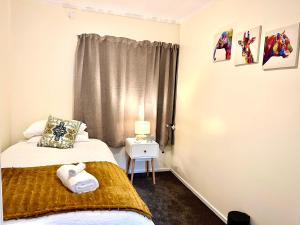 a small bedroom with a bed and a window at Adorable 2 Bedroom Unit Walk to Town in Rotorua