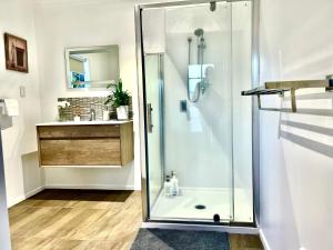 a shower with a glass door in a bathroom at Adorable 2 Bedroom Unit Walk to Town in Rotorua