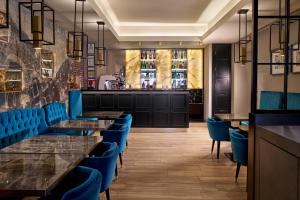 a restaurant with blue chairs and tables and a bar at Hotel Milano & SPA***S in Verona