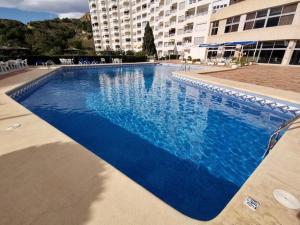 une grande piscine bleue en face d'un bâtiment dans l'établissement Blue Senses 518, à La Vila Joiosa
