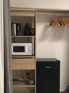 a microwave sitting on a shelf in a kitchen at les hauts de Remire Chambre studio indépendant calme avec piscine in Rémire-Camp