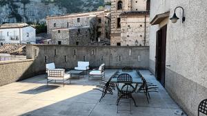un patio con sillas y una mesa en un edificio en Antica Dimora Palazzo Rovitti, en Cerchiara di Calabria